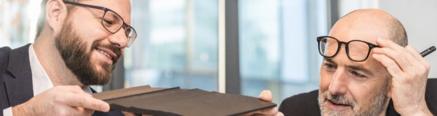 Architect inspecting clay roof or facade tile (Bellus, Facatile) at a meeting room with Wienerberger employee, Fast Forward Commercial Excellence