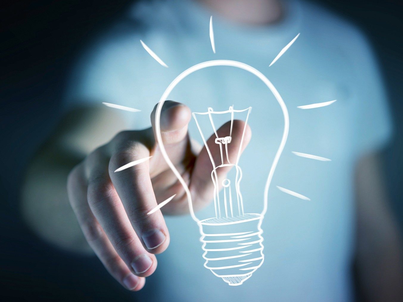 Businessman on blurred background touching a sketch lightbulb