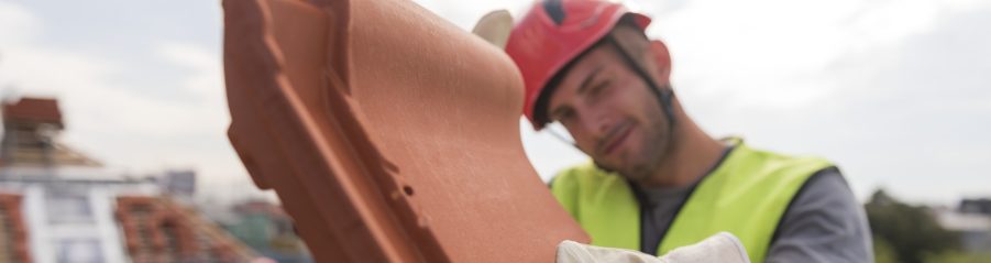 Urban roofers showing product installation roof tiles construction worker wearing hard hat