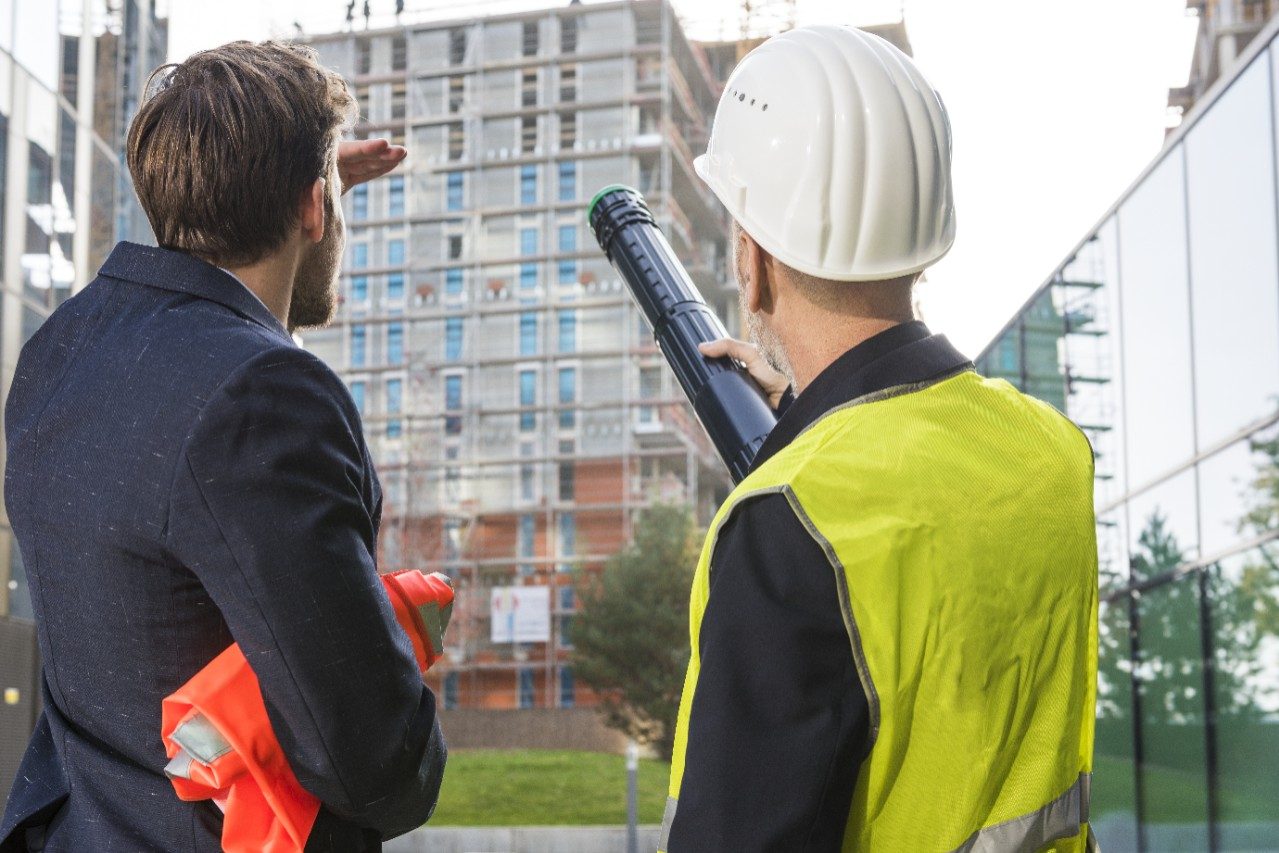 Businessman and architect talking about a new building project at a construction site