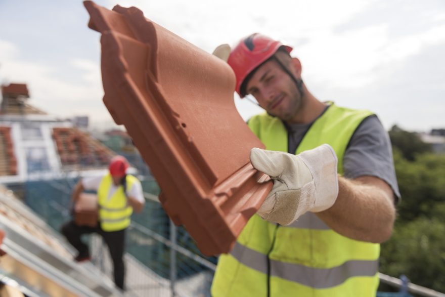 Urban roofers showing product installation roof tiles construction worker wearing hard hat