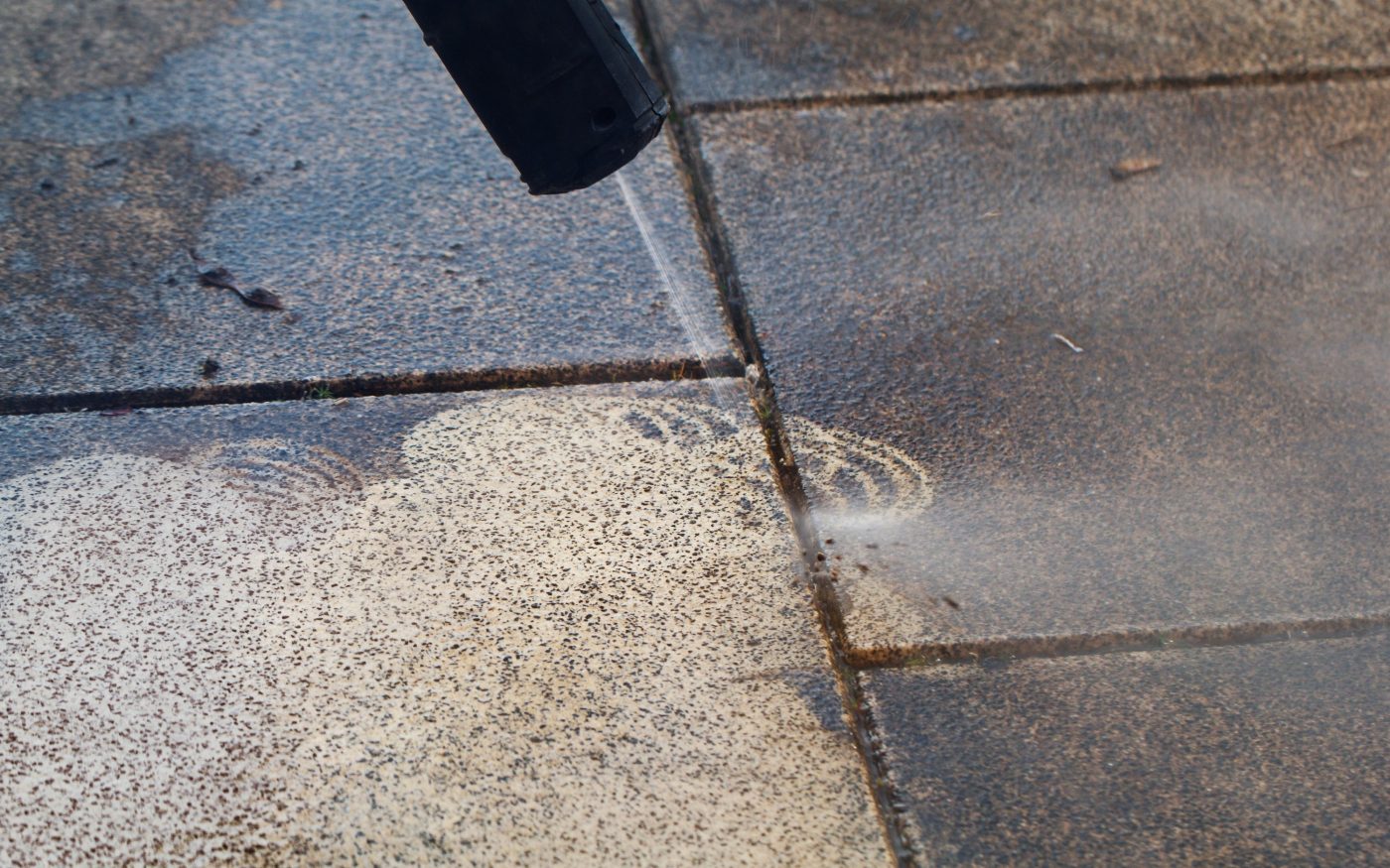 Power cleaning dirty floor, paving slabs with high pressure water jet. Cleaning with high pressure water jet. Cleaning service washing backyard and pavers with pressure water.