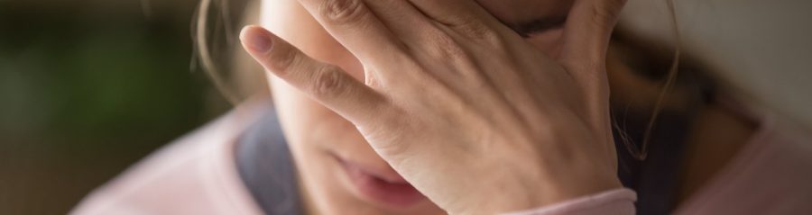 Sad tired young woman touching forehead having headache migraine or depression, upset frustrated girl troubled with problem feel stressed cover crying face with hand suffer from grief sorrow concept